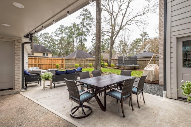 view of patio / terrace featuring a fenced backyard, outdoor dining space, outdoor lounge area, and a trampoline