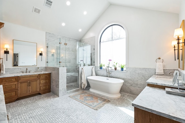 bathroom featuring tile walls, visible vents, and a sink