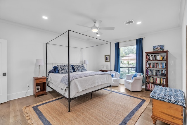 bedroom with visible vents, recessed lighting, crown molding, and wood finished floors