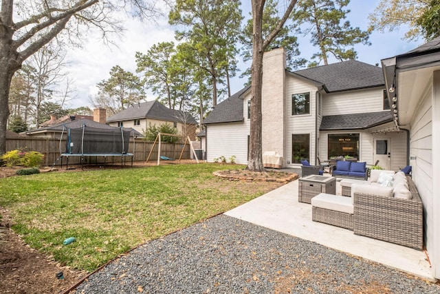 view of yard with an outdoor hangout area, a trampoline, a patio, and fence