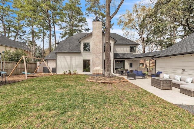 rear view of house featuring fence, a chimney, outdoor lounge area, a yard, and a patio