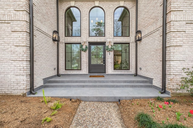 property entrance featuring brick siding