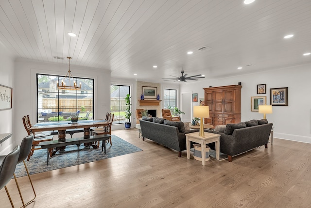 living area featuring visible vents, light wood-style flooring, a fireplace, and wooden ceiling