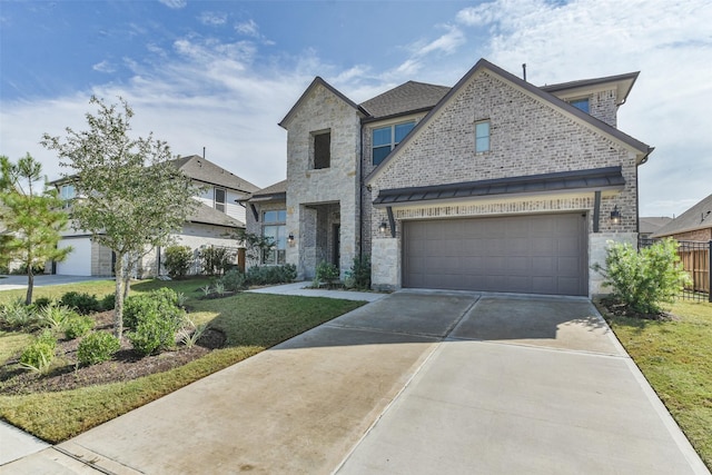 view of front of property featuring a front yard, fence, driveway, a garage, and stone siding