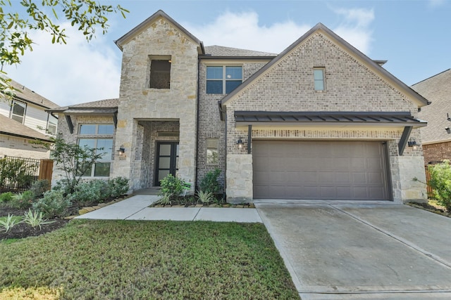 view of front facade featuring driveway, a front lawn, stone siding, an attached garage, and brick siding