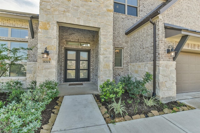 view of exterior entry featuring brick siding, stone siding, and french doors