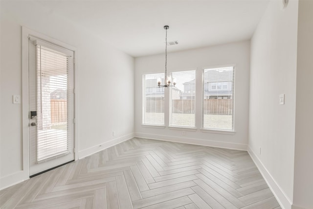 unfurnished dining area featuring a healthy amount of sunlight, baseboards, and a chandelier