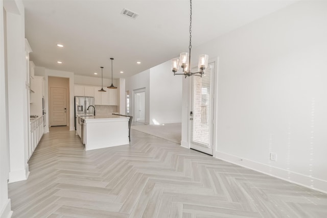 kitchen featuring recessed lighting, visible vents, stainless steel fridge, and open floor plan