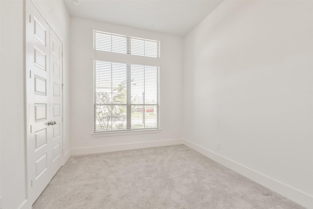 unfurnished room with baseboards and carpet