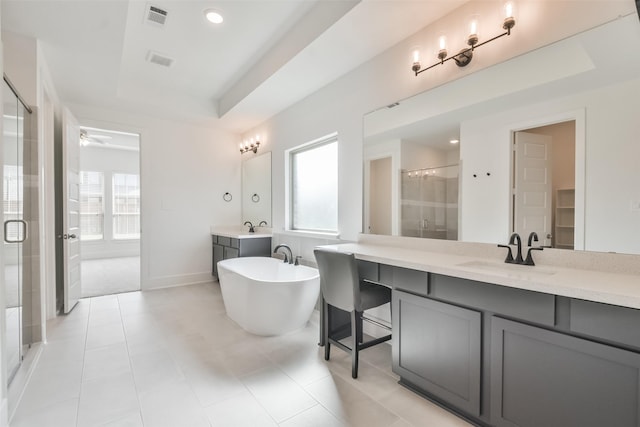 bathroom featuring a sink, visible vents, a raised ceiling, and plenty of natural light