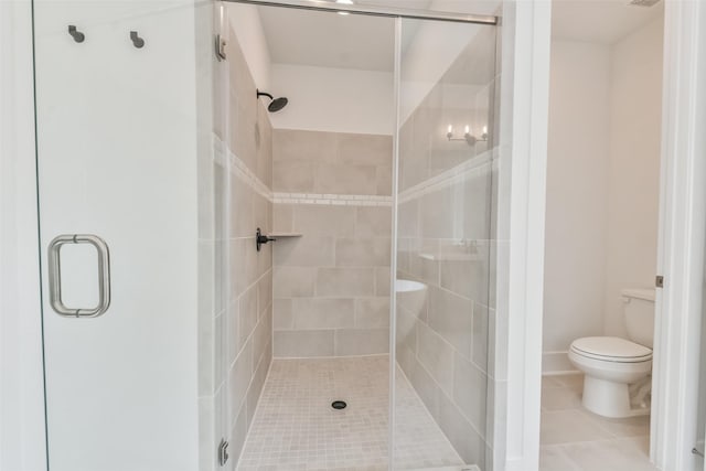 bathroom with tile patterned floors, toilet, and a stall shower