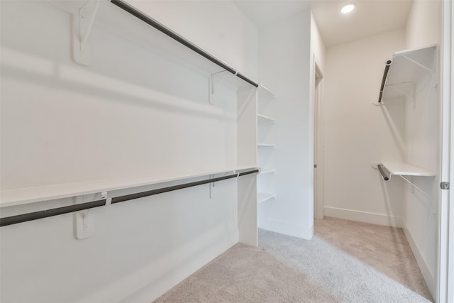 walk in closet with light carpet