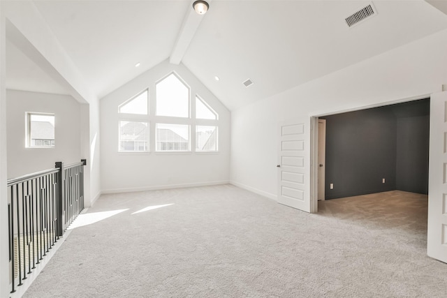 additional living space with beamed ceiling, baseboards, visible vents, and light carpet