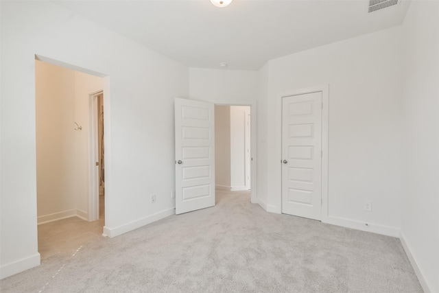 carpeted empty room with visible vents and baseboards