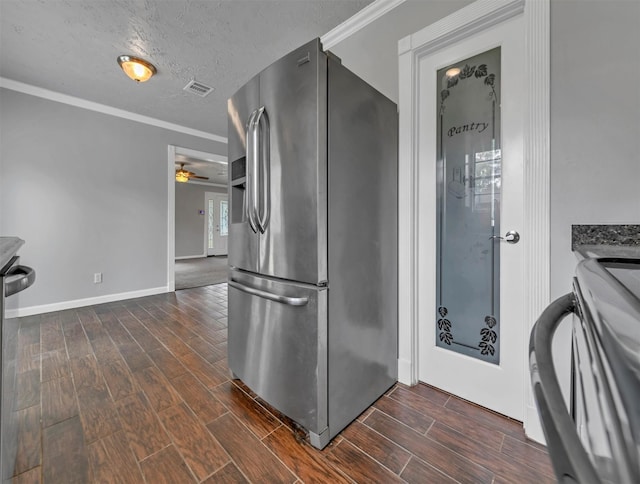 kitchen with crown molding, wood finish floors, stainless steel fridge, a textured ceiling, and range