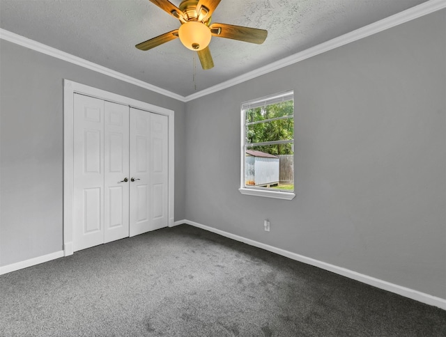 unfurnished bedroom featuring baseboards, ornamental molding, a closet, a textured ceiling, and carpet flooring