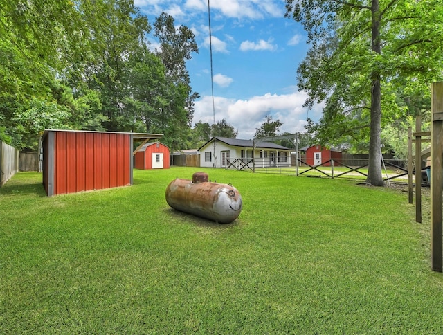 view of yard with an outbuilding, a fenced backyard, and a shed