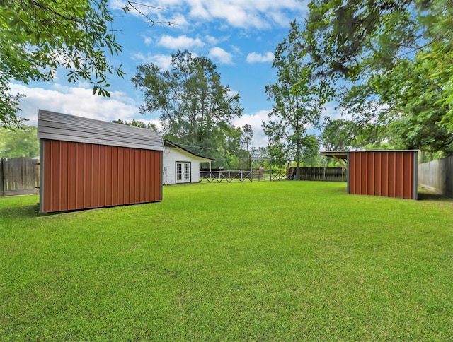 view of yard featuring an outbuilding, a fenced backyard, and a storage shed