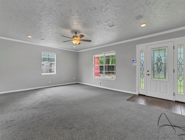 foyer featuring visible vents, ornamental molding, baseboards, and dark colored carpet