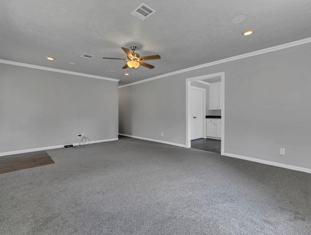 spare room featuring visible vents, baseboards, a ceiling fan, and dark carpet