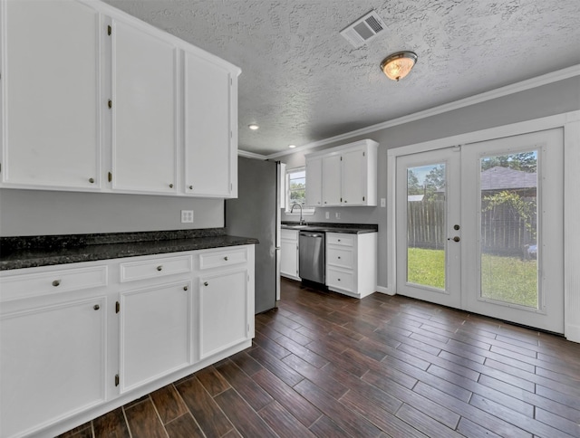 kitchen with visible vents, dark wood finished floors, ornamental molding, a sink, and stainless steel dishwasher