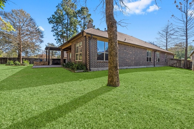 view of side of home featuring brick siding, a yard, a chimney, and a fenced backyard