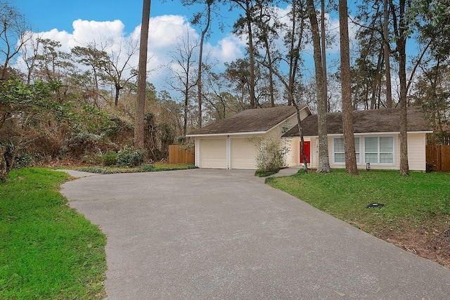 single story home featuring driveway, a front yard, a garage, and fence