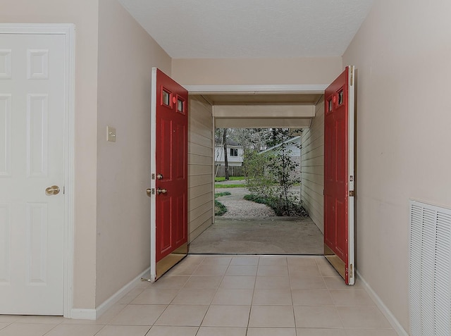 entrance foyer featuring light tile patterned floors, baseboards, and visible vents