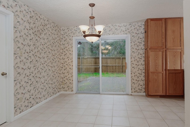 unfurnished dining area featuring wallpapered walls, plenty of natural light, and a textured ceiling