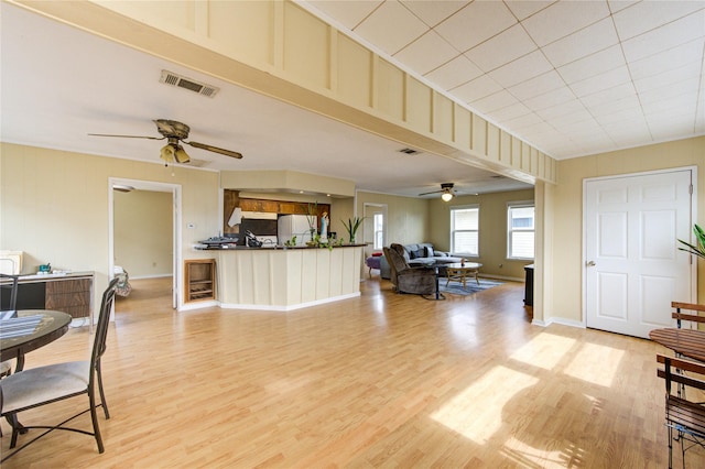 living room with visible vents, ceiling fan, and light wood finished floors