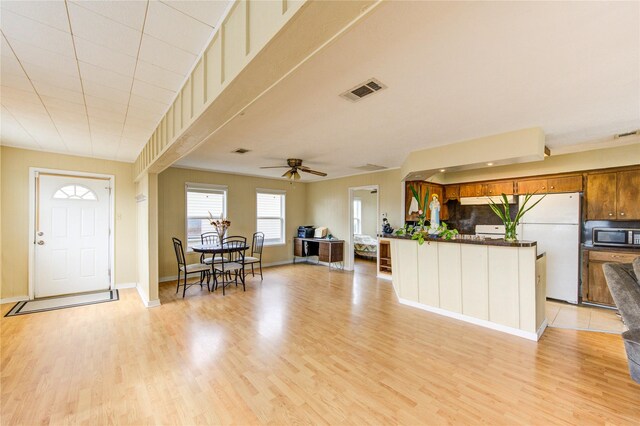 interior space featuring visible vents, baseboards, light wood-style floors, and ceiling fan