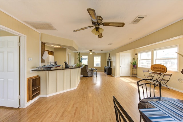 kitchen featuring dark countertops, open floor plan, visible vents, and light wood-type flooring