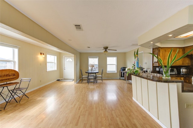 kitchen featuring light wood-style floors, visible vents, baseboards, and dark countertops