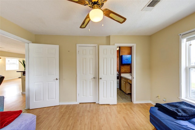 bedroom with baseboards, visible vents, and light wood finished floors