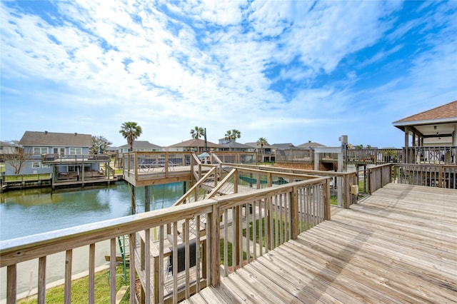 view of dock with a residential view and a water view