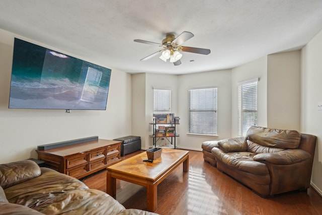 living area featuring ceiling fan, baseboards, and wood finished floors