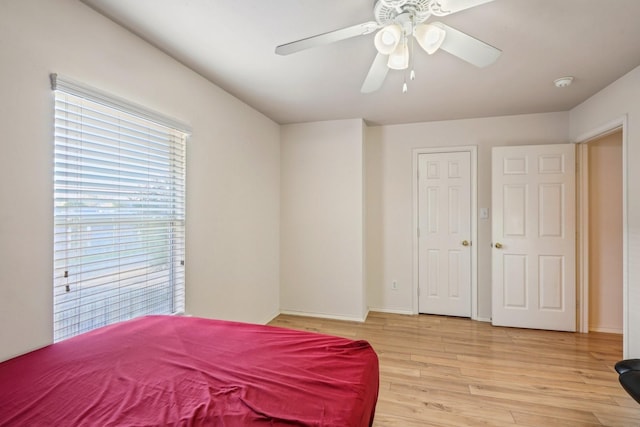 bedroom with baseboards, light wood-style floors, and a ceiling fan