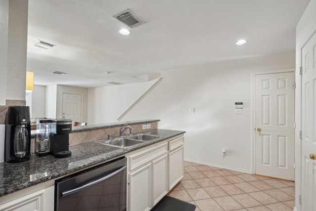 kitchen featuring white cabinetry, dishwashing machine, visible vents, and a sink