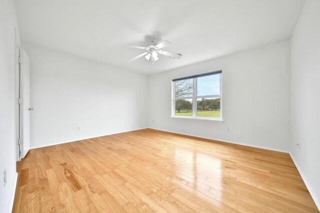 empty room with a ceiling fan and light wood-style floors