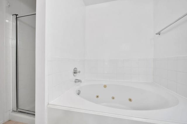 full bath featuring a stall shower and a jetted tub