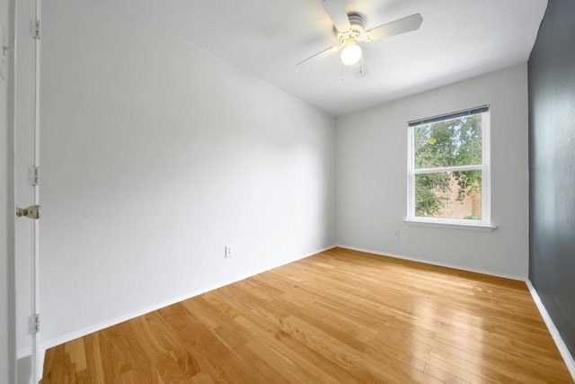 spare room with a ceiling fan, baseboards, and light wood finished floors