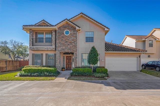 view of front of home with fence, concrete driveway, stucco siding, a garage, and stone siding