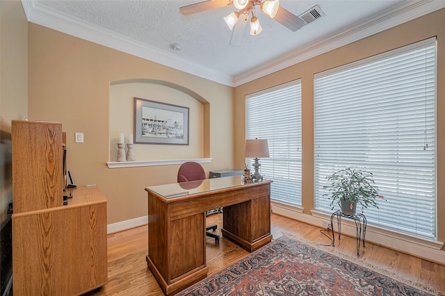 office space with visible vents, light wood-style floors, ceiling fan, and crown molding