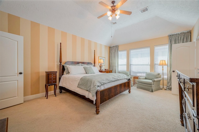 bedroom featuring a textured ceiling, visible vents, wallpapered walls, lofted ceiling, and light carpet