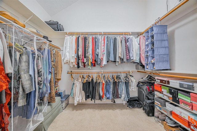 walk in closet with carpet floors and vaulted ceiling