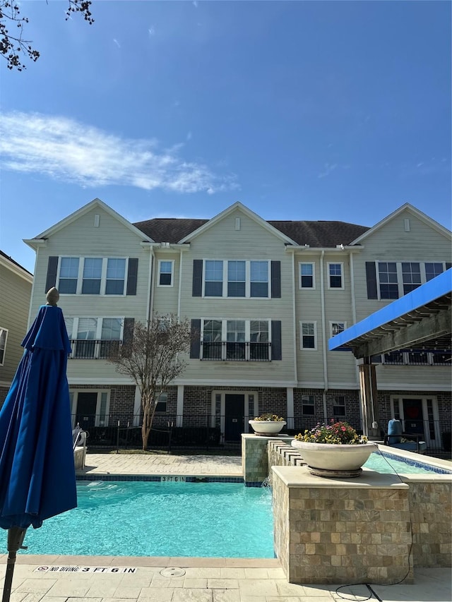 community pool with a patio and fence