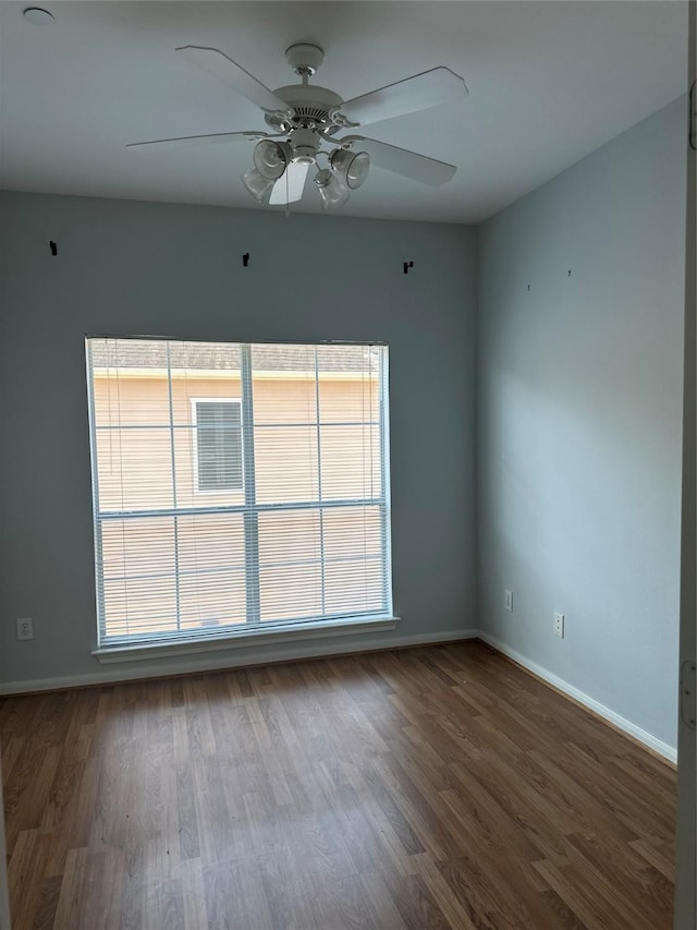 unfurnished room featuring a ceiling fan, baseboards, and wood finished floors