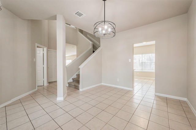 empty room featuring visible vents, baseboards, stairway, light tile patterned flooring, and a notable chandelier