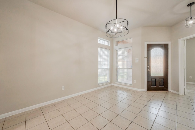 entrance foyer with light tile patterned floors, baseboards, and a notable chandelier