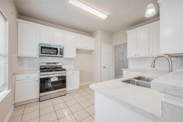 kitchen featuring a sink, white cabinets, light stone counters, and stainless steel appliances